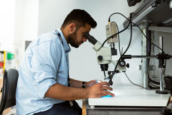 Ein Forschungsangestellter sieht in ein Mikroskop
